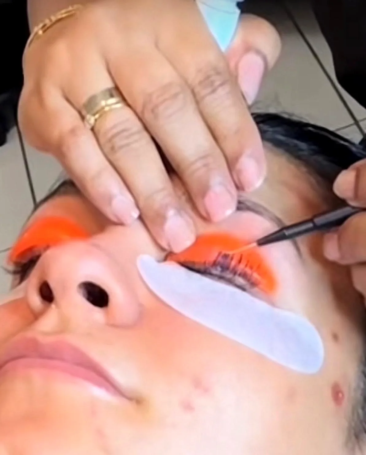 Wimpern werden mit Pinsel gefärbt, Augenpads unter den Wimpern